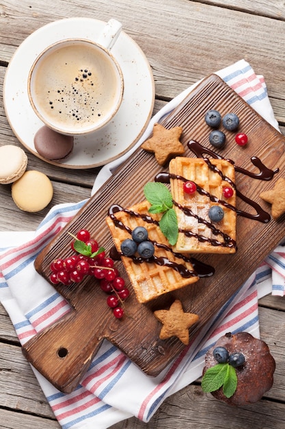 Doces de café e waffles com bagas