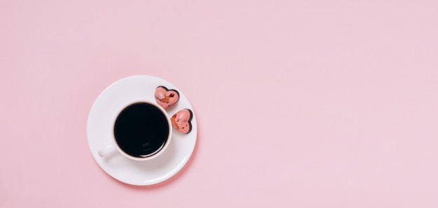 Doces de chocolate corações xícara de café fundo rosa Espaço de cópia de layout plano Conceito de férias 14 de fevereiro Dia dos Namorados