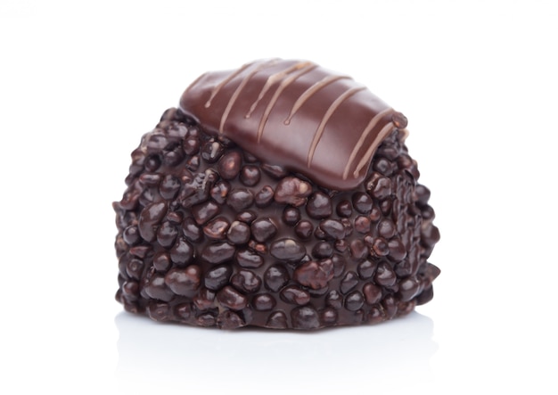 Doces de chocolate escuros luxuosos com parte superior do chocolate de leite e creme de cacau no branco.