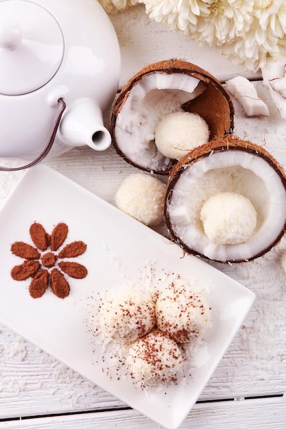 Foto doces de coco caseiros no prato, na luz de fundo