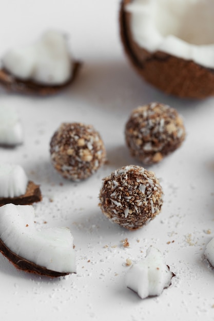 Foto doces de coco com chocolate sobre um fundo claro de madeira. doces naturais sem açúcar.