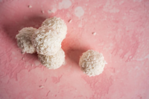 Doces de coco com nozes em fundo rosa Raffaello Foto de alta qualidade