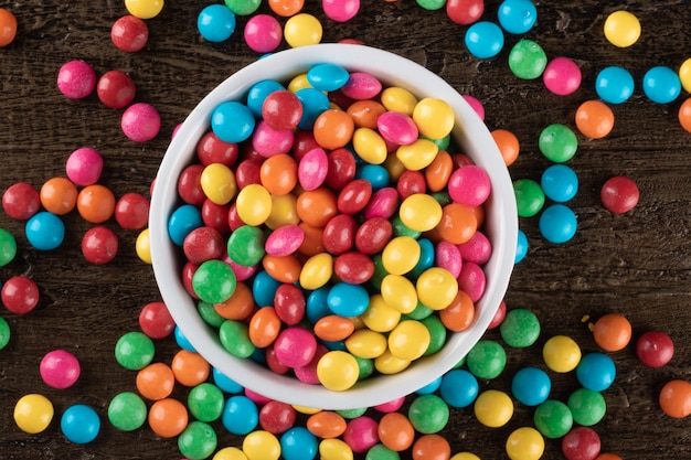 Foto doces de confetes coloridos em uma tigela sobre a mesa.