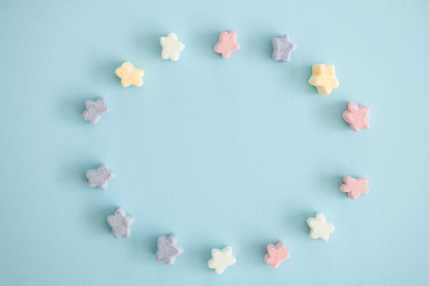 Doces de cor doce em forma de estrelas sobre fundo azul