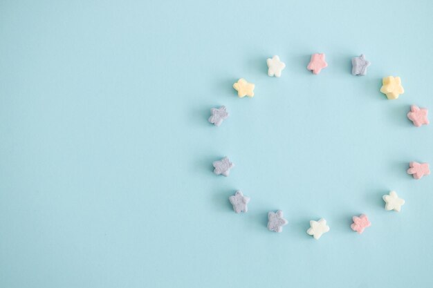 Doces de cor doce em forma de estrelas sobre fundo azul