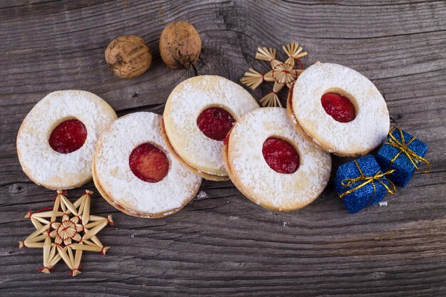 Doces de Natal caseiros com açúcar em pó e geleia na superfície de madeira velha