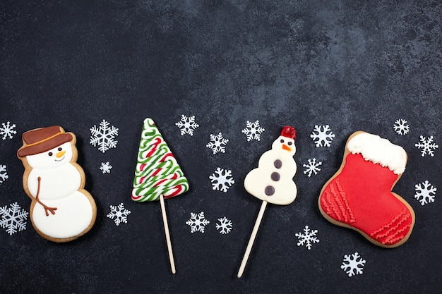 Doces de natal em forma de boneco de neve. árvore de natal papai noel em fundo preto