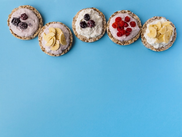 Doces de pão crocante e frutas em um azul. Há espaço para texto na parte inferior.