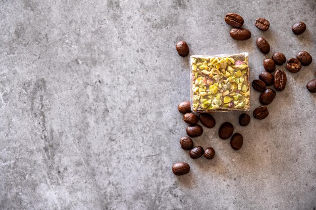 doces de pistache com grãos de café em fundo cinza