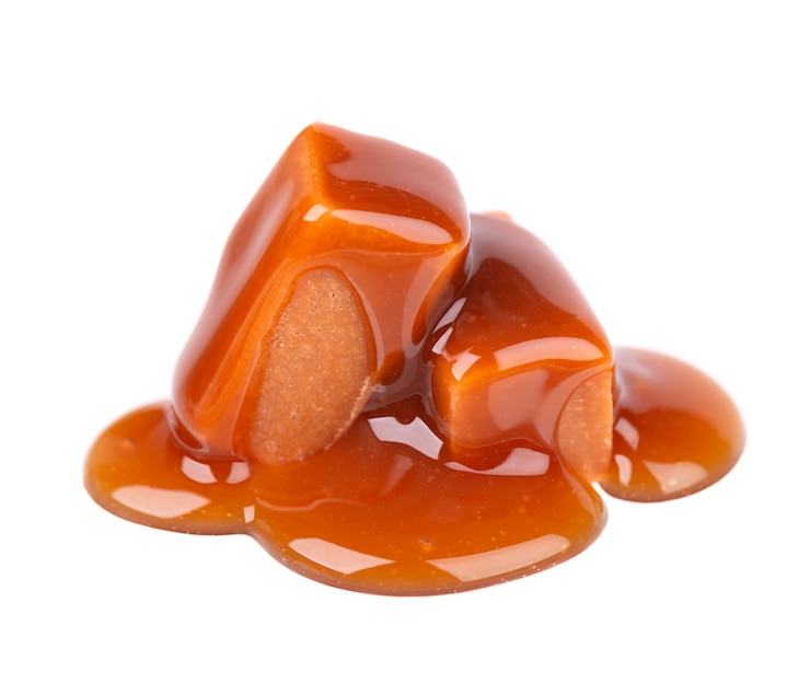 Doces doces e molho de caramelo, isolados no branco. Caramelo delicioso.