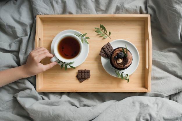 Doces e uma xícara com uma bebida em uma bandeja de madeira