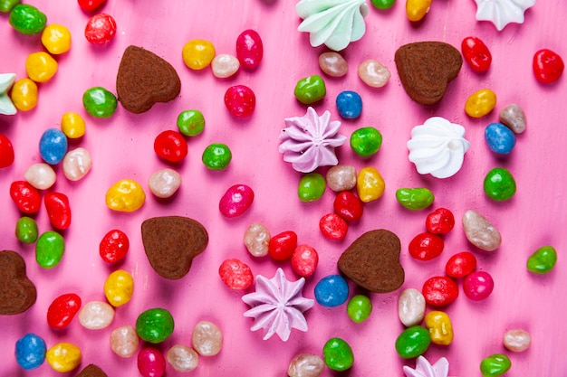 Doces em uma mesa rosa. Dia dos namorados. Doces em formato de coração.