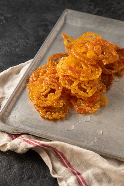 Doces indianos Jalebi em uma bandeja de metal em um escuro