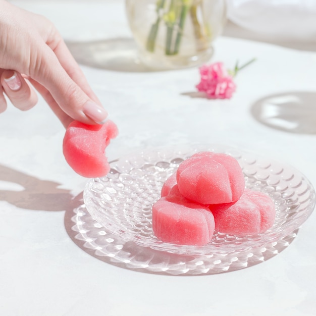 Doces japoneses Mochi rosa em uma mesa branca