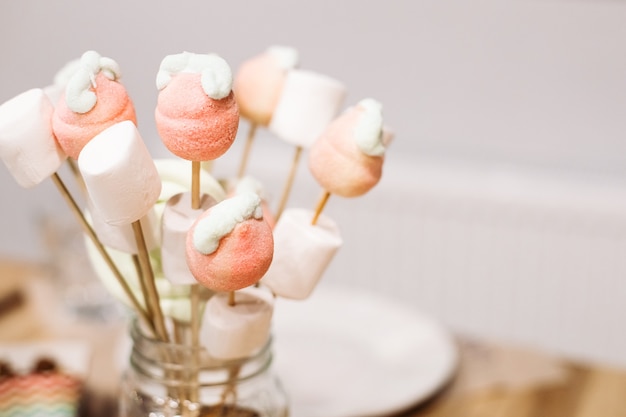 Doces, marshmallows de baunilha e pirulitos em palitos para um jantar festivo. Catering para festas, publicidade de confeitaria. Foto de alta qualidade