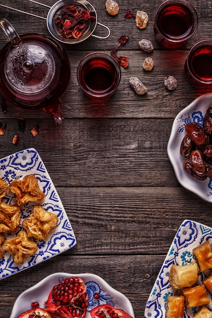 Doces orientais com chá de hibisco.