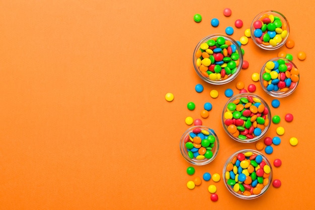 Foto doces redondos de cores diferentes em tigelas e potes vista superior de uma grande variedade de doces e balas com espaço para cópia