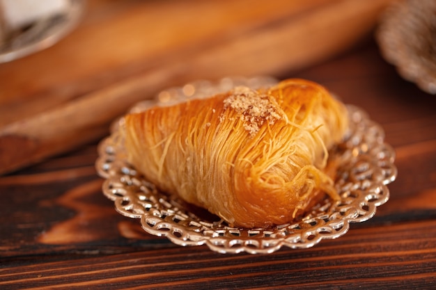 Doces turcos em pratinho sobre fundo de madeira marrom