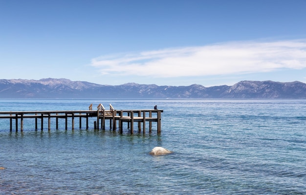 Dock no lago cercado por montanhas na temporada de verão