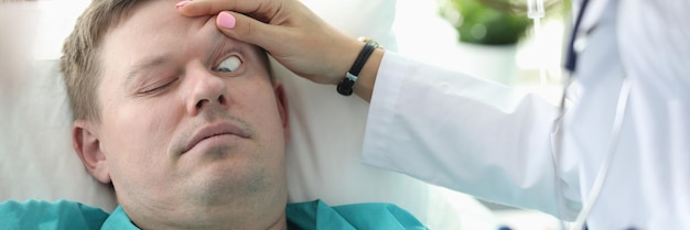 El doctor abre los ojos a la clínica inconsciente del paciente