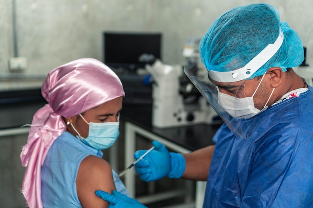 Doctor administrando una vacuna a una mujer con cáncer