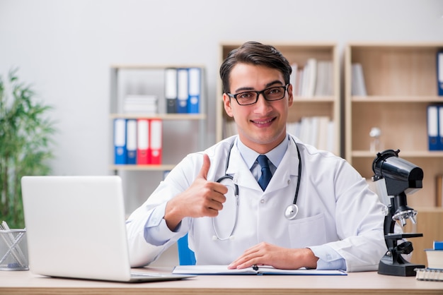 Doctor adulto joven con ordenador portátil