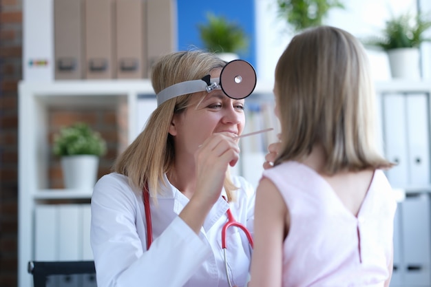 Doctor alegre examina el retrato de nasofaringe infantil