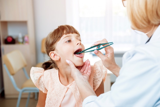 Doctor amable pediatra con niño paciente en la clínica