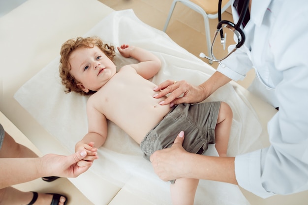 Doctor amable pediatra con niño paciente en la clínica