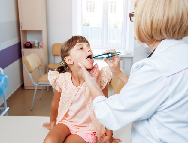 Doctor amable pediatra con niño paciente en clínica