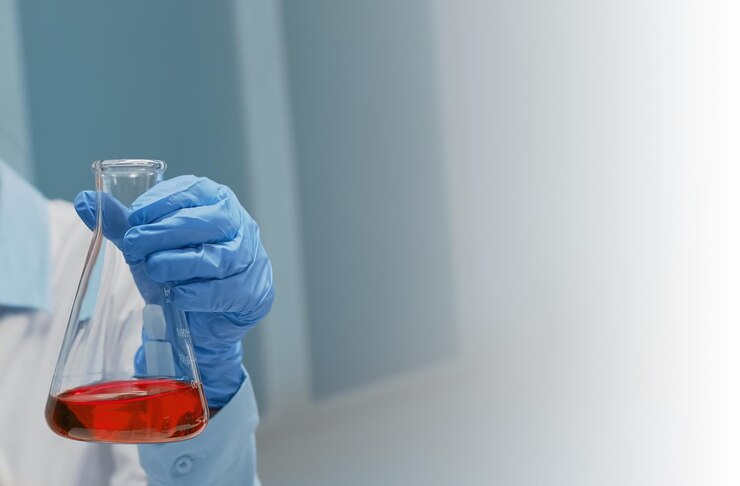 Doctor analizando vaso químico en el laboratorio químico sosteniendo matraz con solución roja