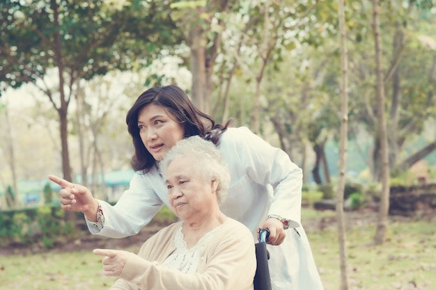 Doctor ayudando a mujer senior en silla de ruedas