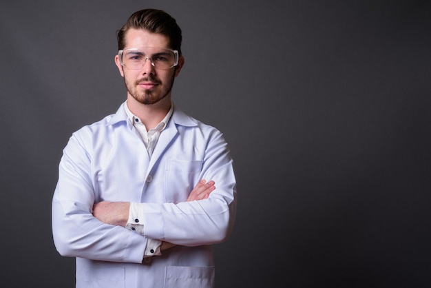 Doctor barbudo guapo joven con gafas protectoras