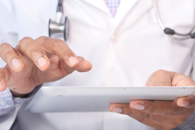 doctor en bata blanca está usando una tableta digital