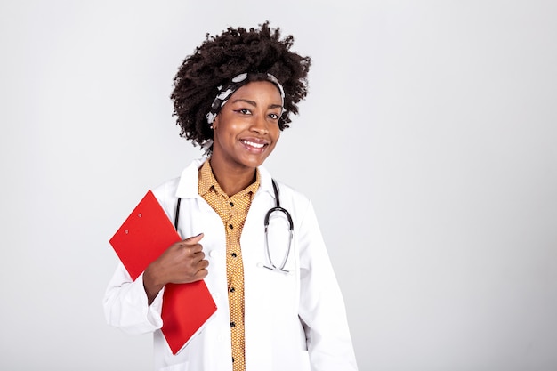 Doctor en bata blanca y un estetoscopio sosteniendo el portapapeles con recetas y posando