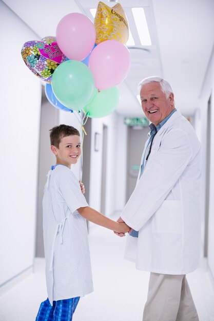 Doctor caminando con paciente en el pasillo del hospital