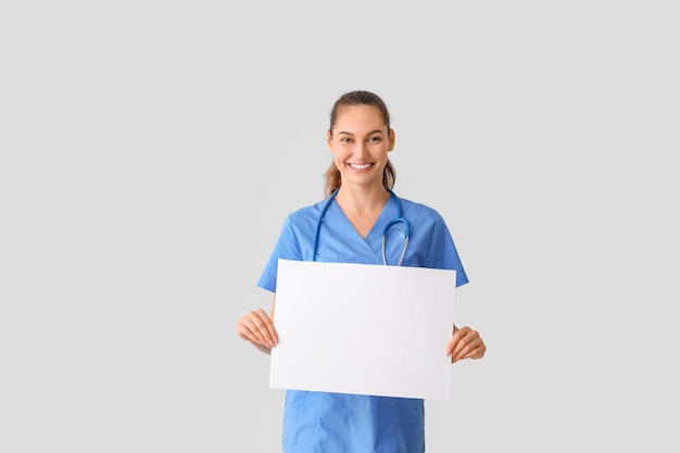 Doctor con cartel en blanco sobre fondo claro