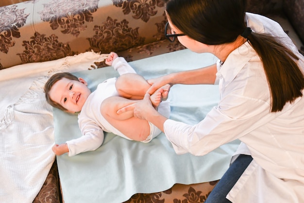 El doctor en casa hace gimnasia para el niño.