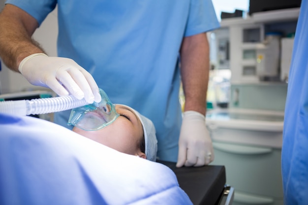 Doctor colocando una máscara de oxígeno en la cara de un paciente