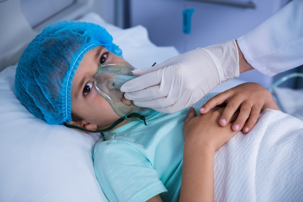 Doctor colocando una máscara de oxígeno en el paciente en sala