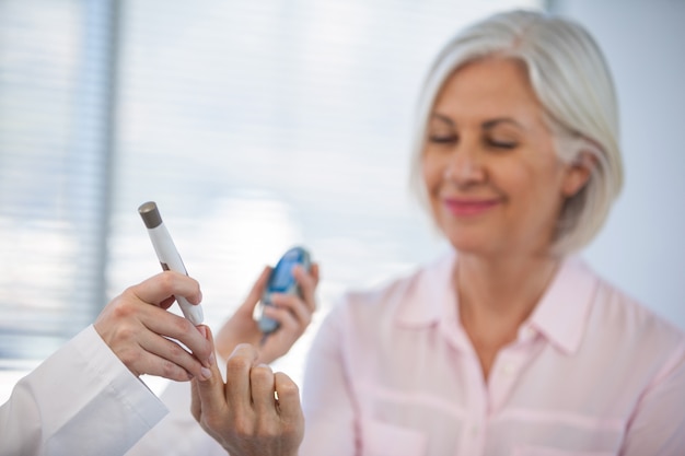 Foto doctor comprobando el nivel de glucosa en pacientes diabéticos