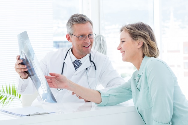 Doctor conversando con su paciente y sosteniendo la radiografía