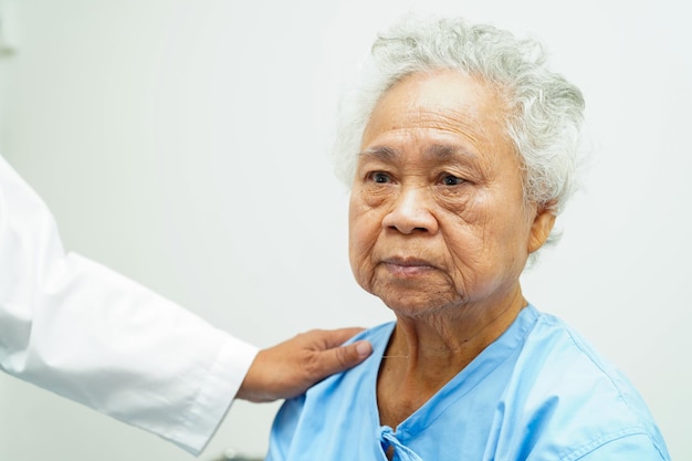 Doctor cuidando ayuda y animando a una anciana asiática anciana paciente en el hospital de la clínica