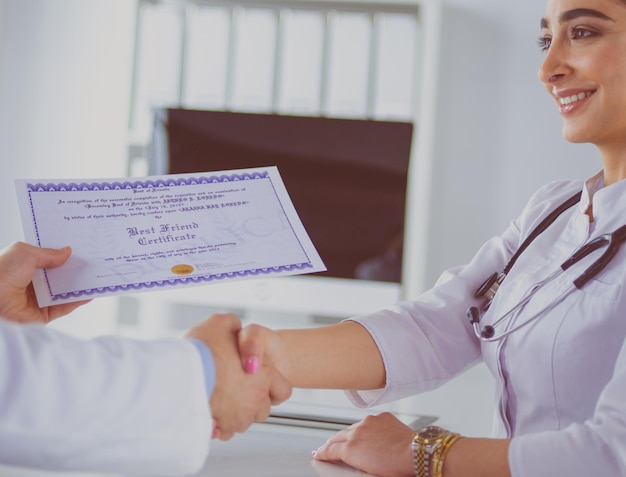 El doctor le da la mano a un paciente aislado de fondo blanco