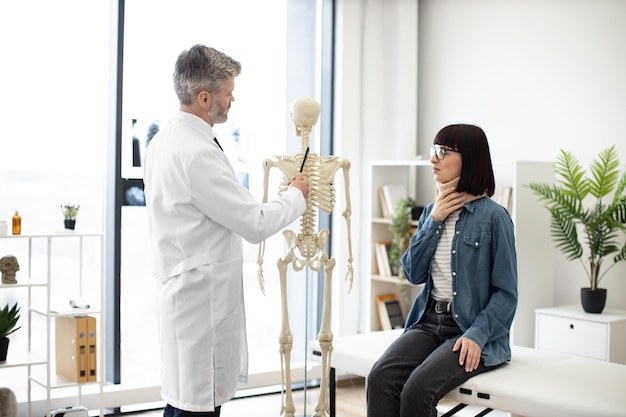 Doctor dando consejos a mujeres con collarín en la sala de examen