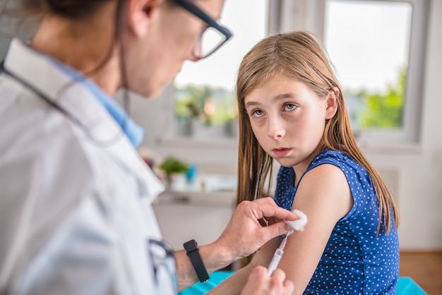 Doctor dando una vacuna a una niña