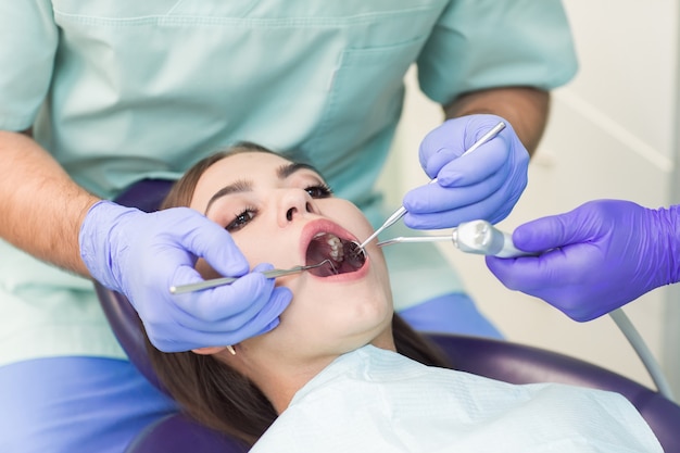 Doctor dentista con un asistente de trabajo en una clínica dental.