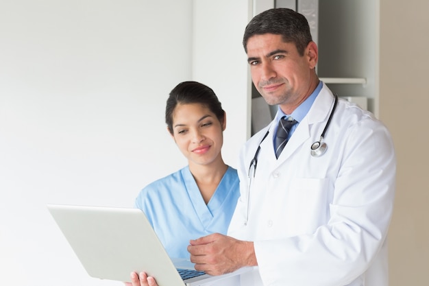 Doctor y enfermera con la computadora portátil en el hospital