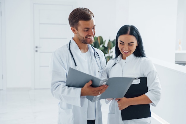 El doctor y la enfermera morena se encuentran en el hospital y hablan en el trabajo.