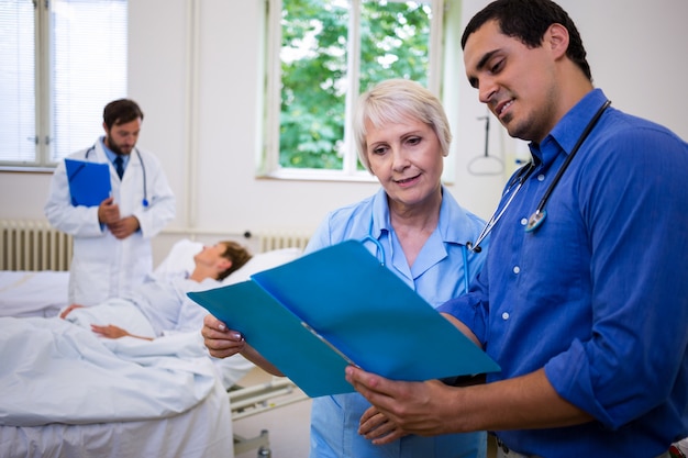 Foto doctor y enfermera revisando un informe médico